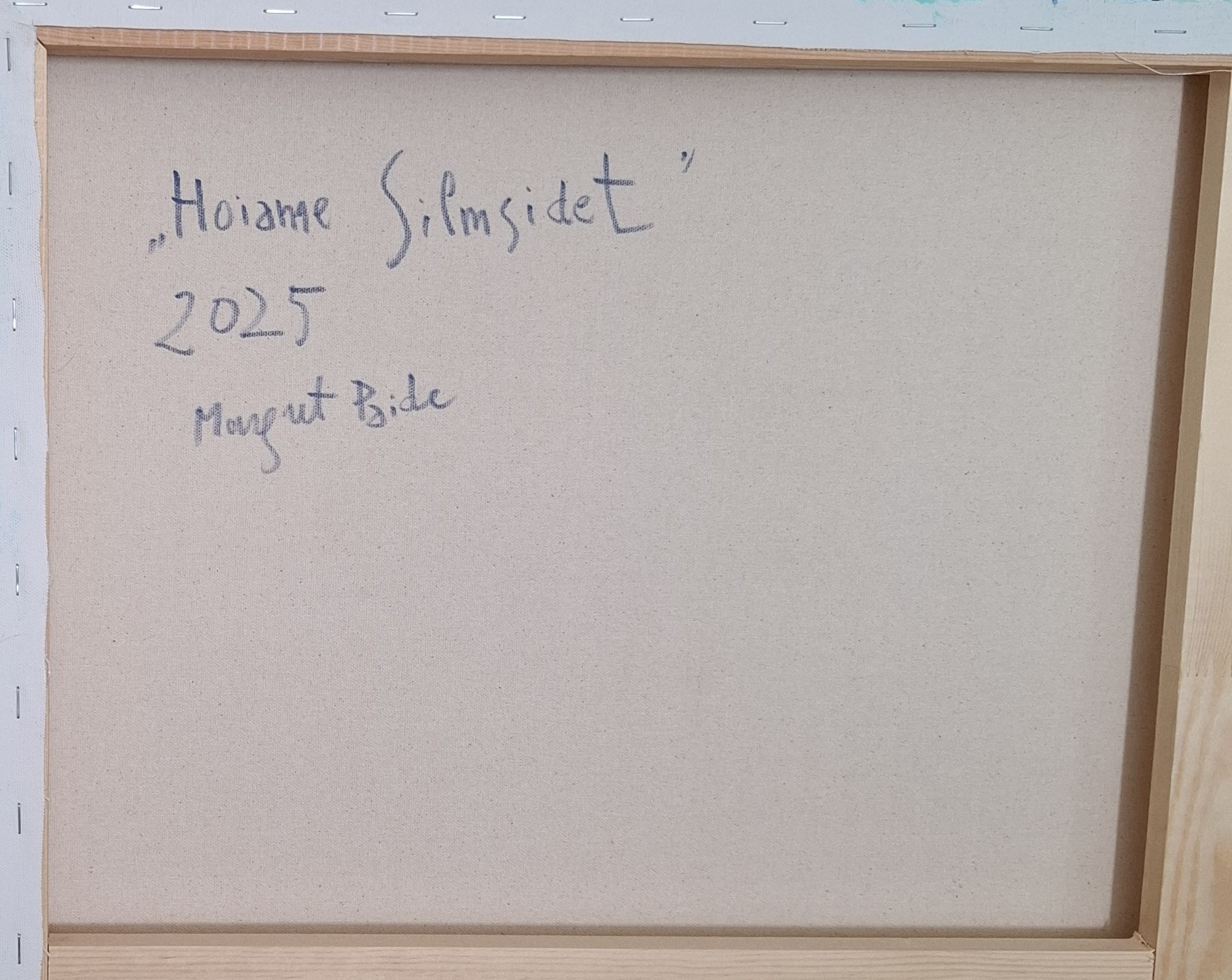 Back of a stretched canvas with a wooden frame, featuring a handwritten artist signature and the year 2025.